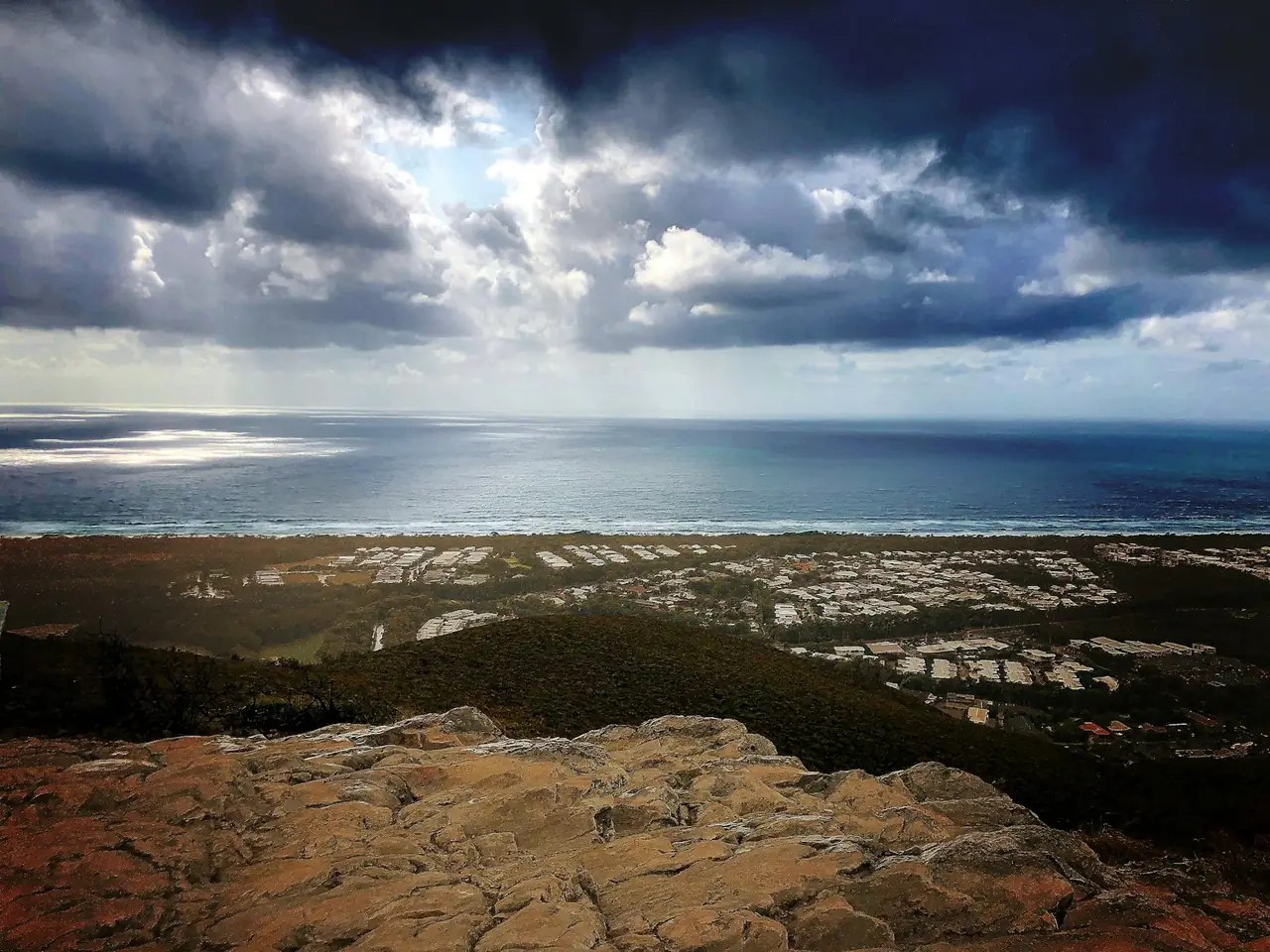 Storm clouds over the ocean, seen from the rocky top of Mount Coolum