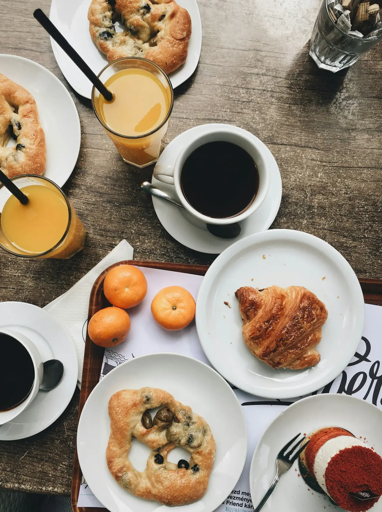 Croissants, pastries, coffee and juice spread across a table