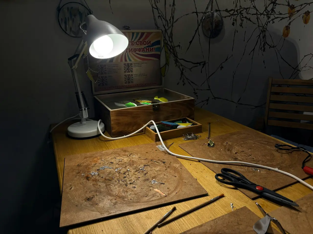 A timber desk with a lamp and carving work laid out