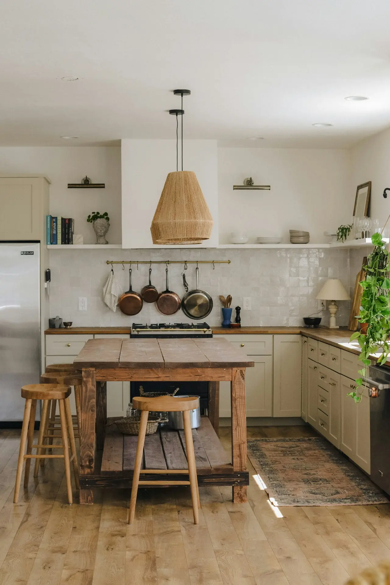 A kitchen with a timber island, open shelves and pendant light