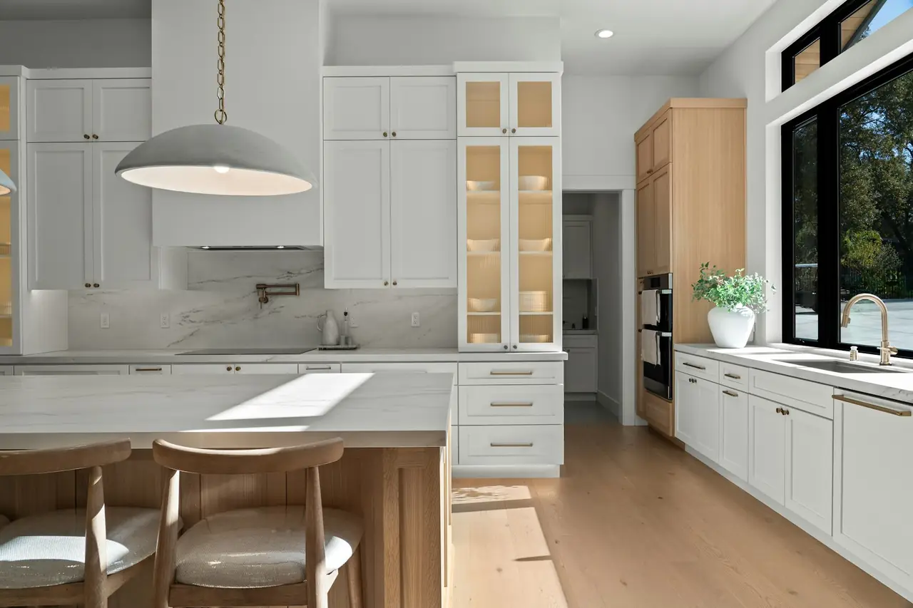 A bright kitchen with a timber island and pendant light