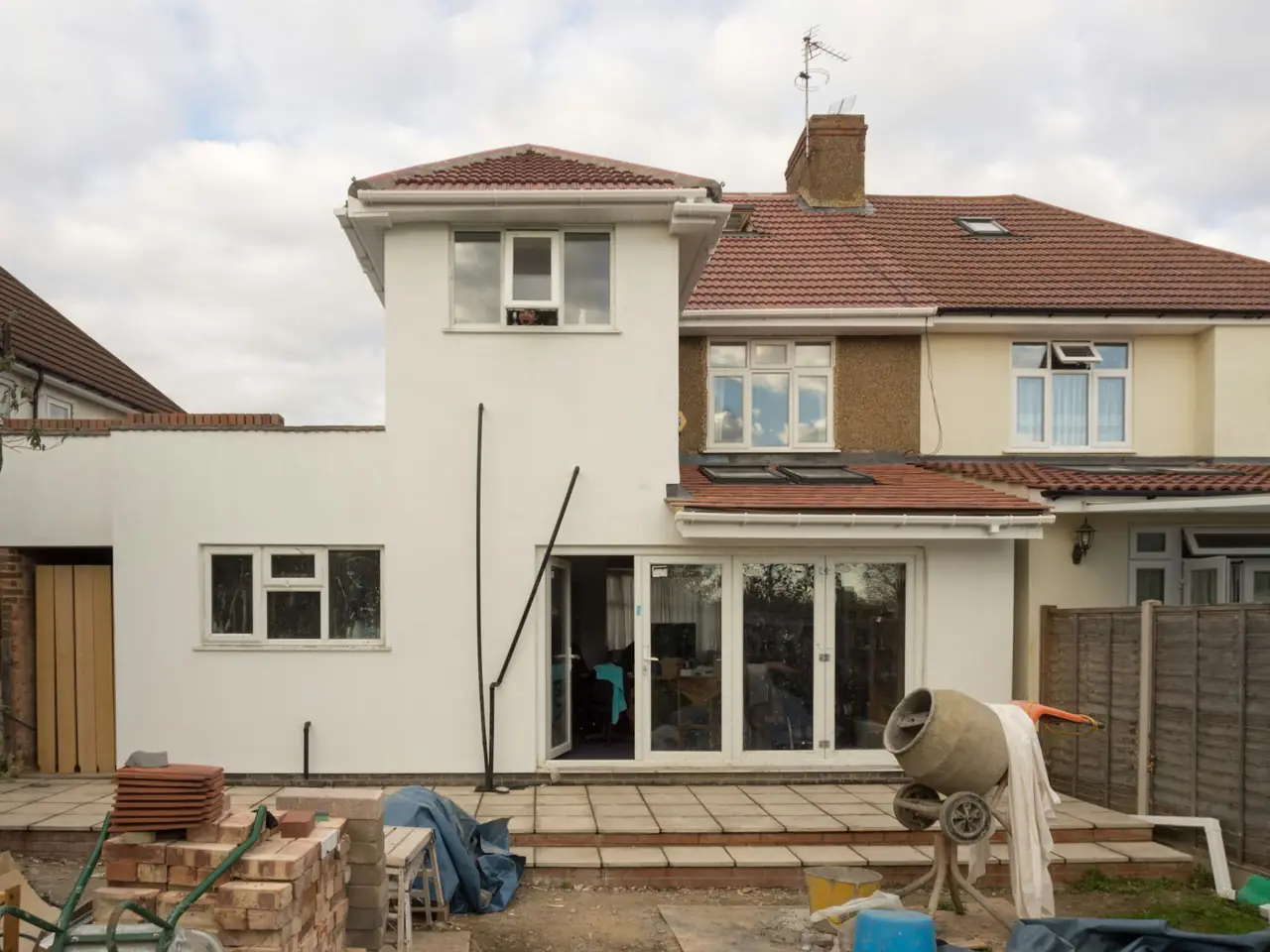 A rendered rear extension going up on a brick house