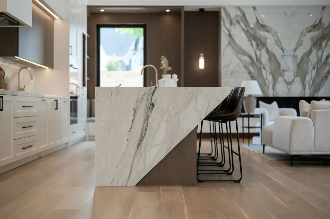 A kitchen with a marble island and timber floors