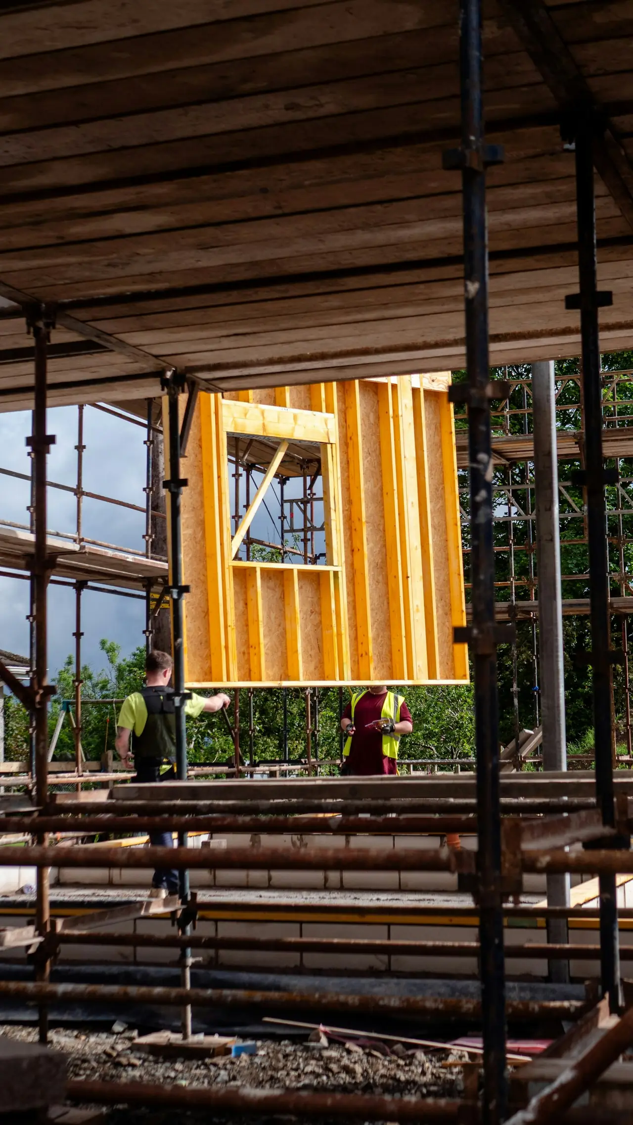 Scaffolding around a timber-framed wall going up