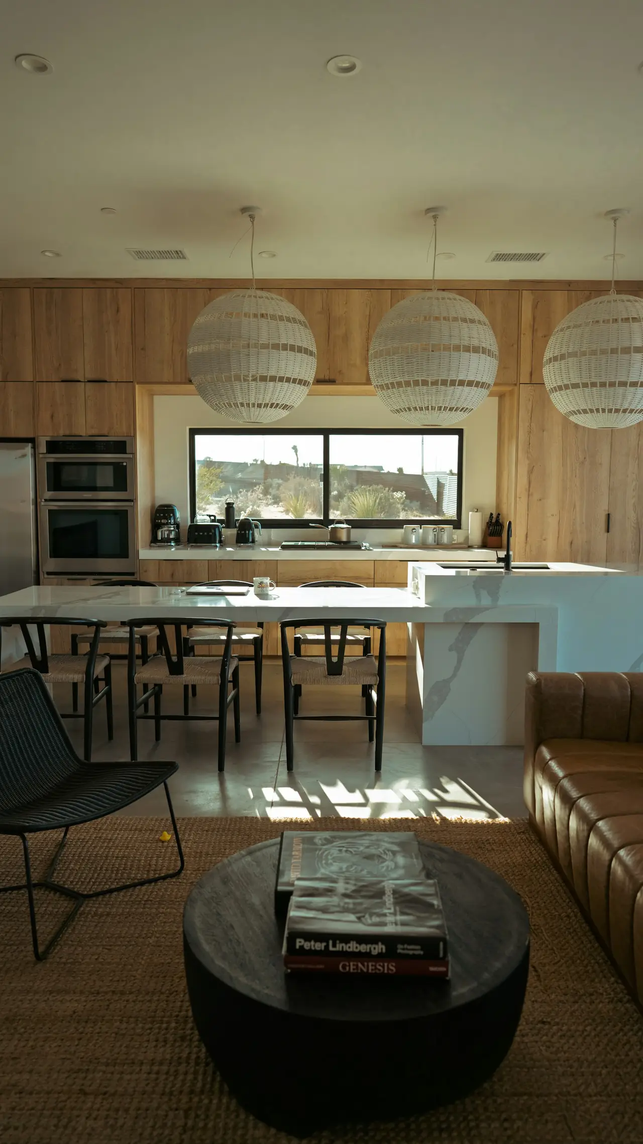 An open-plan living area lit by round pendant lamps