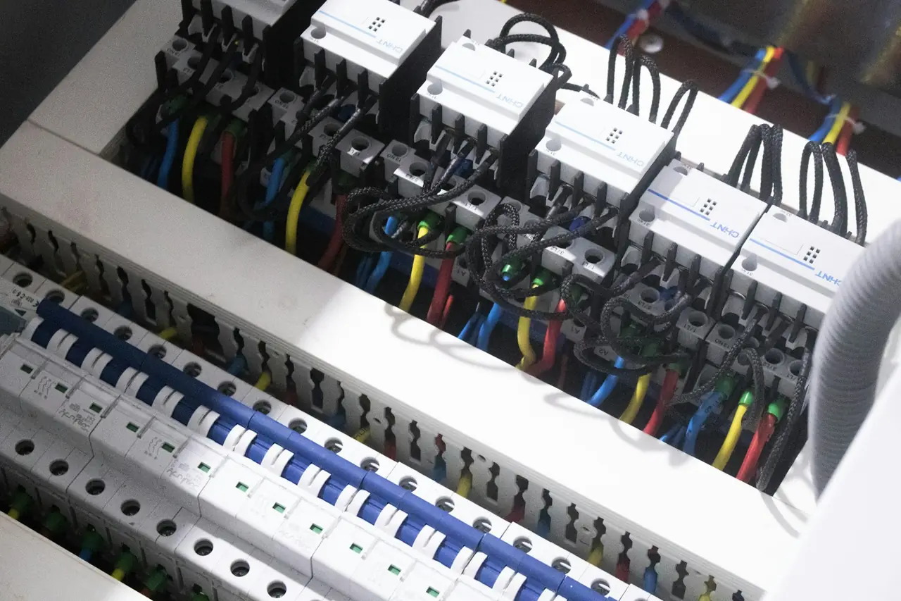 Neatly run wiring and breakers inside an open switchboard