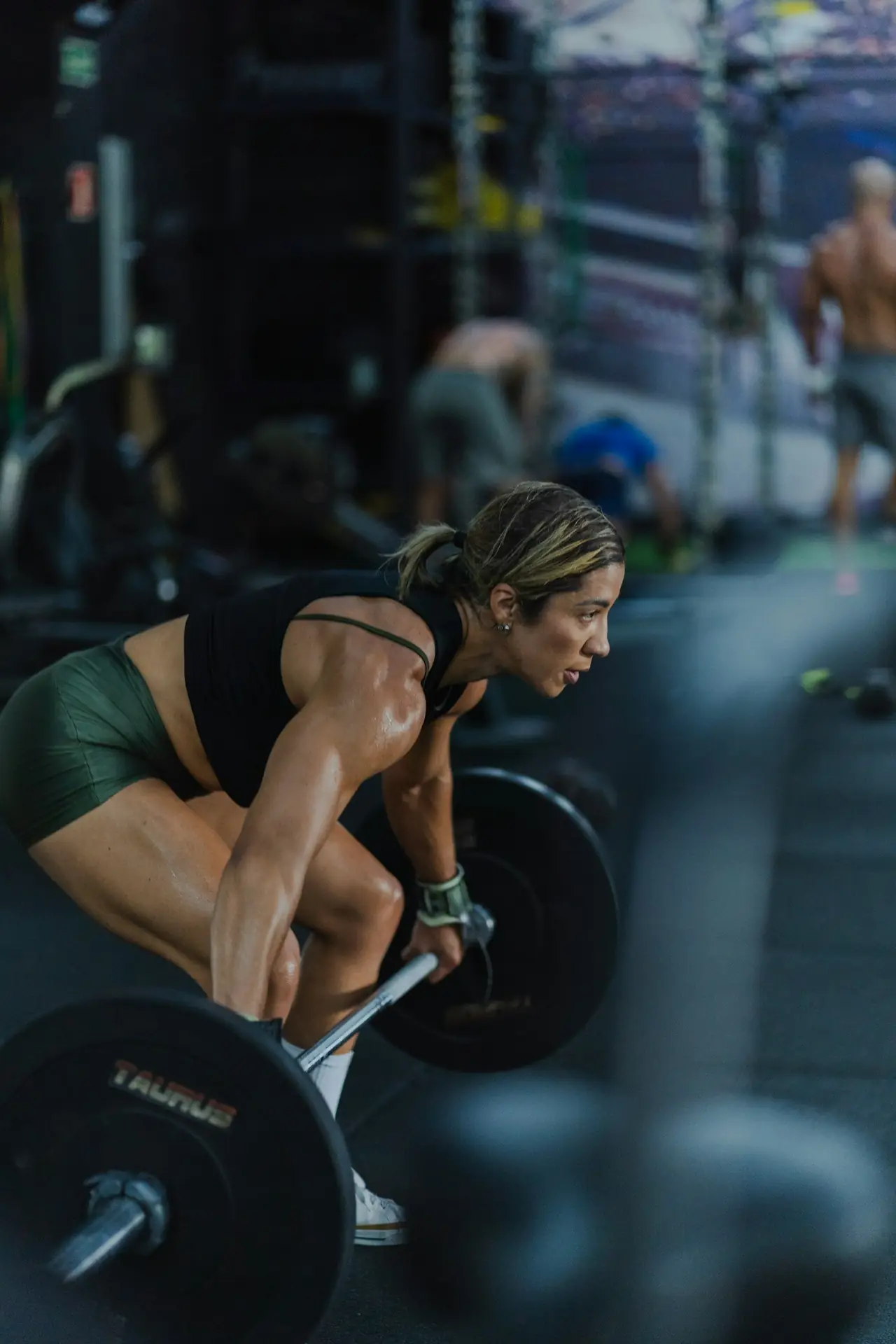 A woman setting up a deadlift with a loaded bar