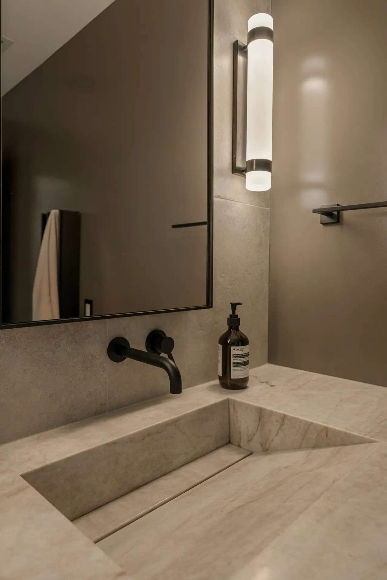 A stone basin with a black wall-mounted tap