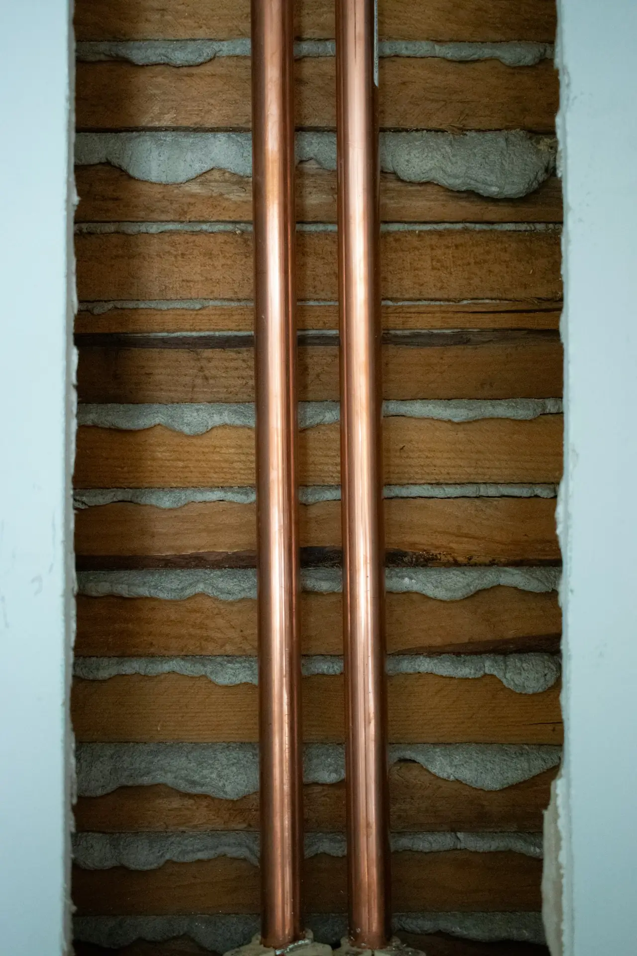 Copper pipes fixed along a wall