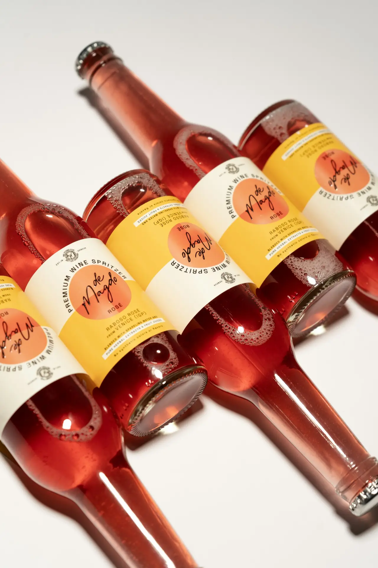 Bottles with red and yellow labels laid on a white surface