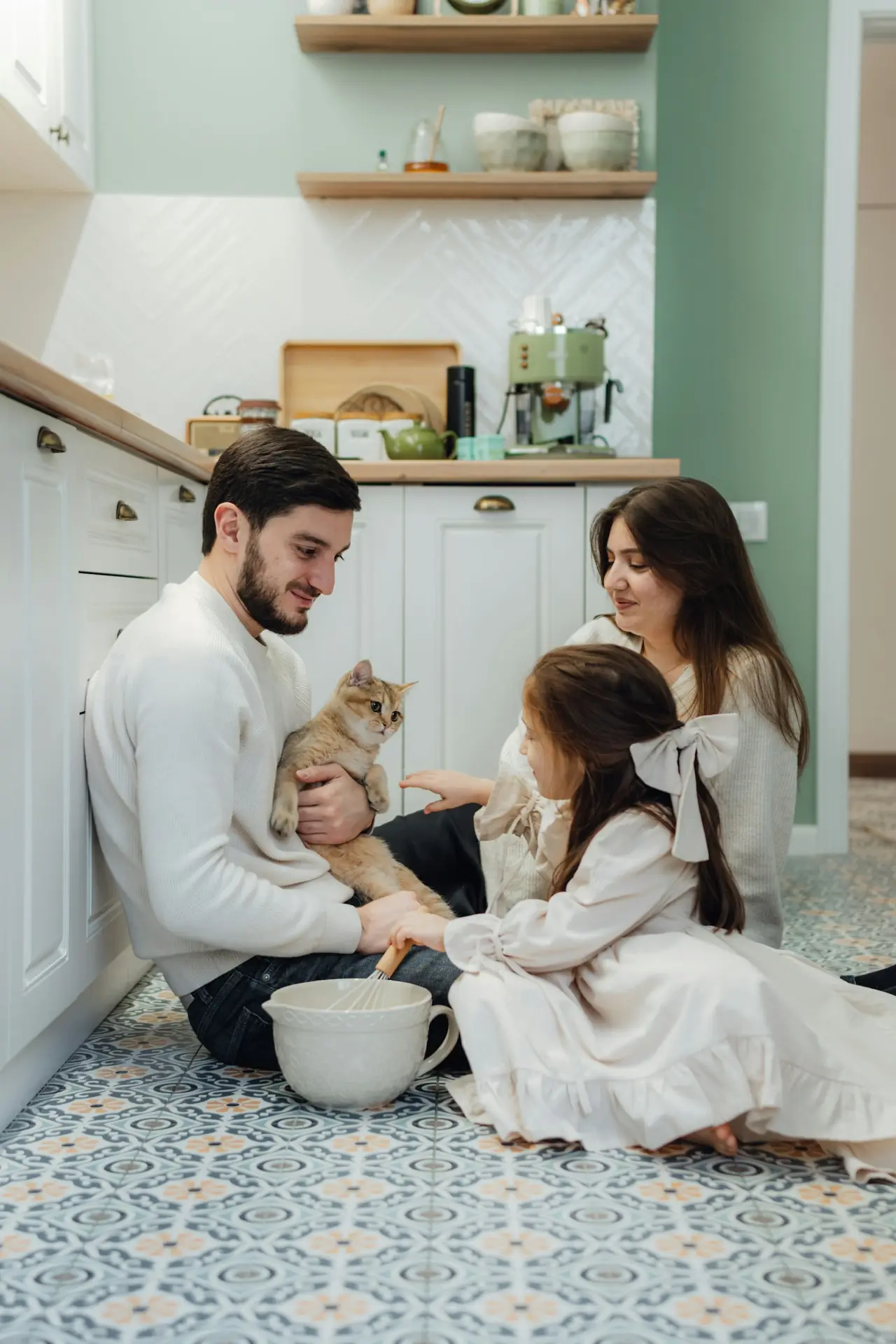 A family of four on a patterned kitchen floor with a cat