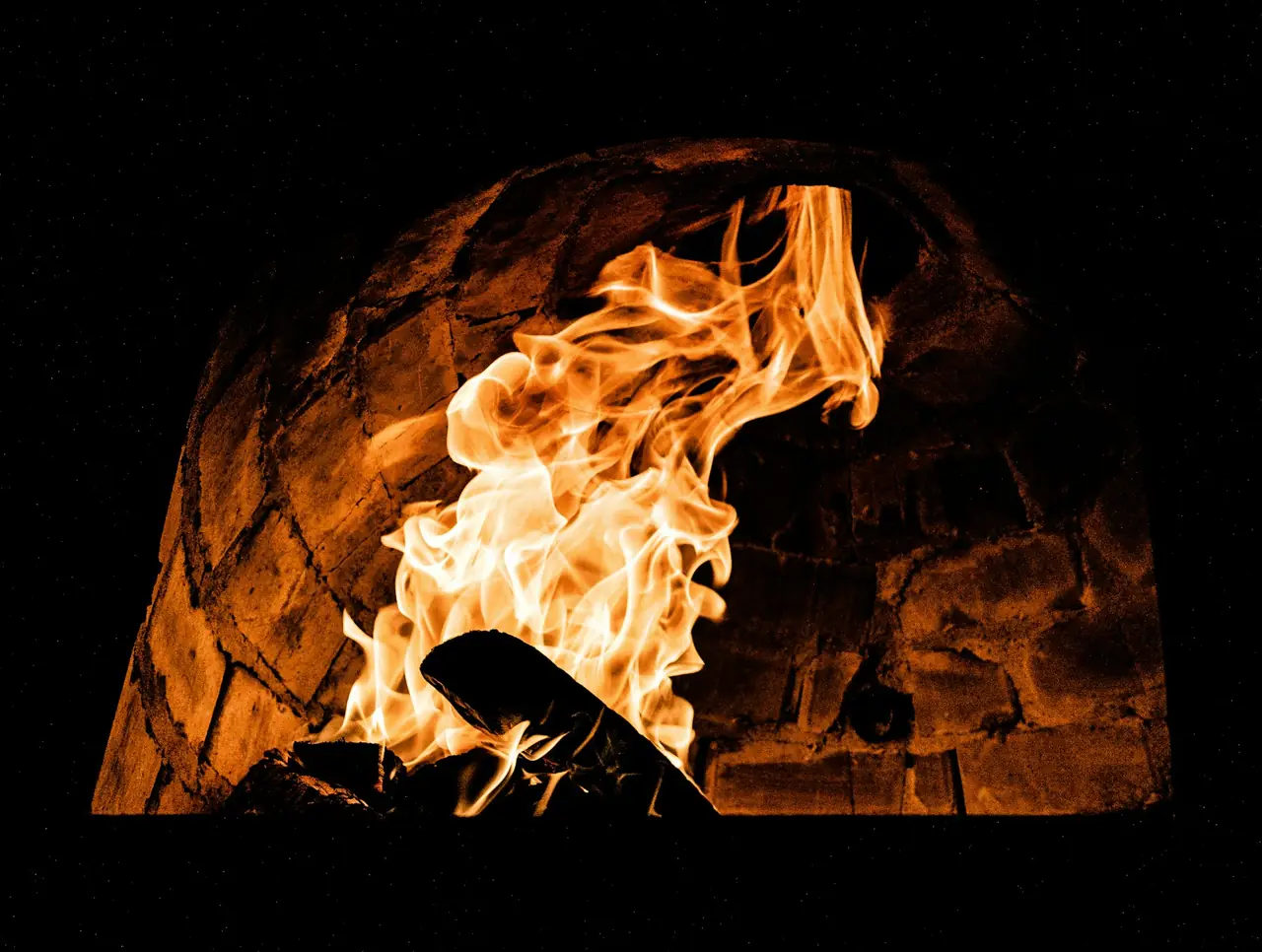 Flames rising inside a brick wood-fired oven